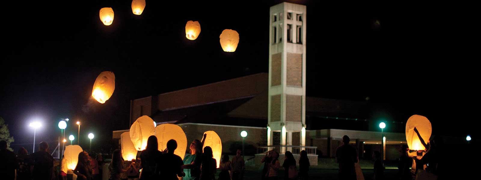 学生们在钟楼前向夜空放飞灯笼