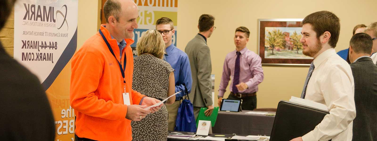 students interact with professionals at career fair