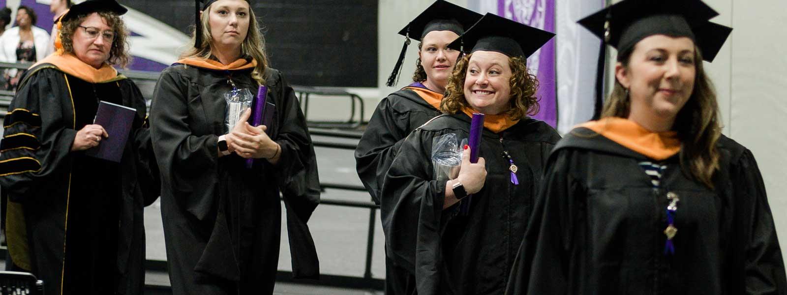 master of nursing graduates leave commencement carrying diplomas